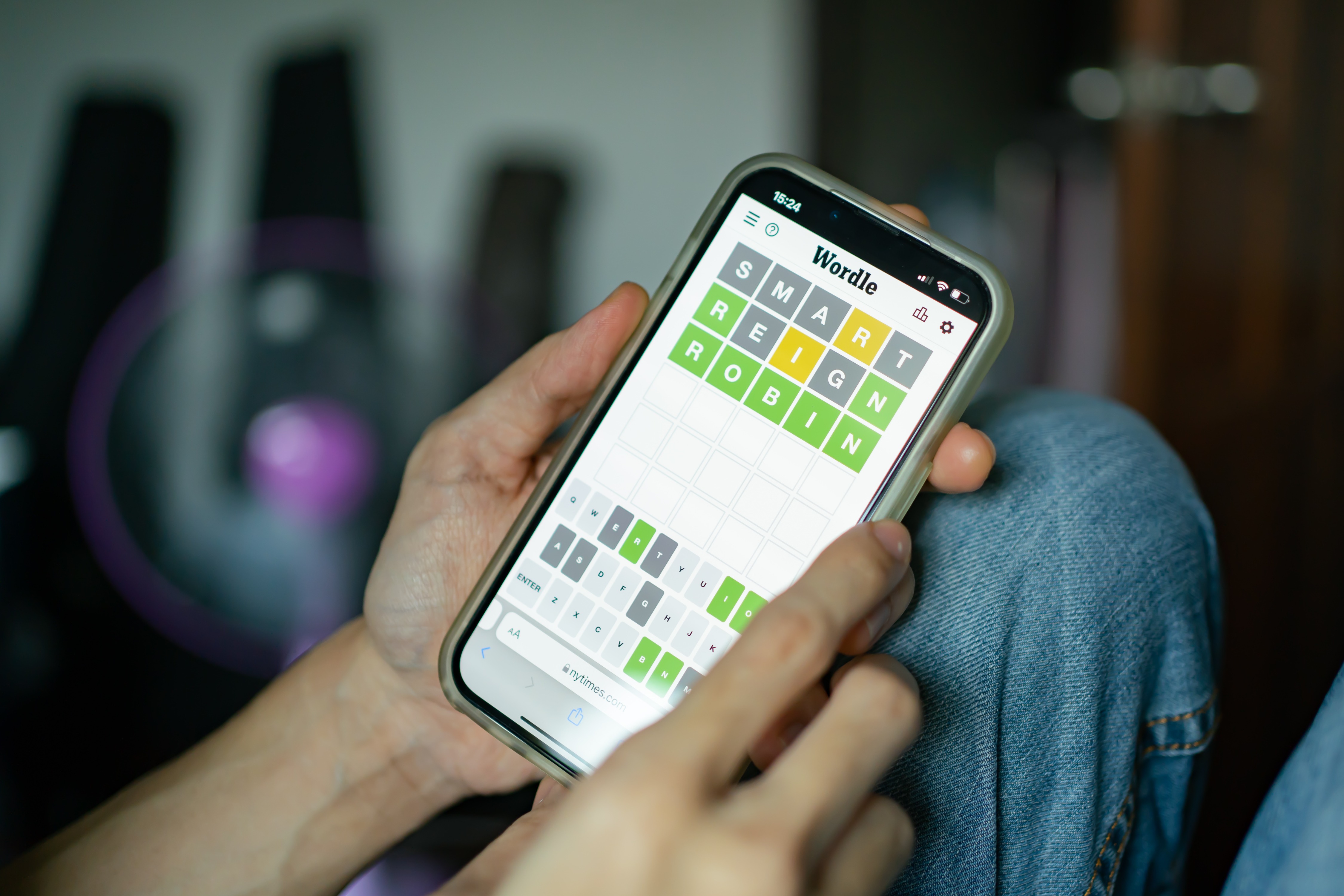 شخصی در حال بازی Wordle با گوشی هوشمند.