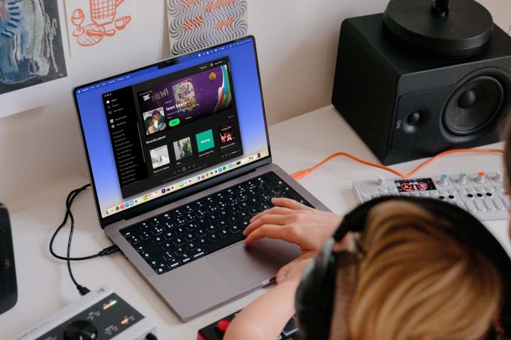 افرادی که هدفون دارند و در مک بوک به Spotify گوش می دهند.